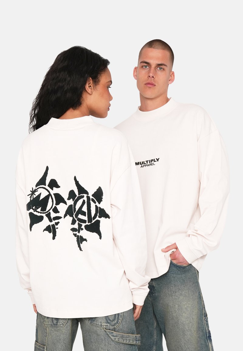 Weiße Langarm-T-Shirts aus Baumwolle mit einem schwarzen Grafikdesign auf dem Rücken und einem kleinen Logo auf der Vorderseite. Legere Passform.