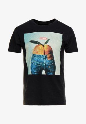 Czarny t-shirt Levi's z grafiką dwóch brzoskwiń w niebieskich dżinsach, z zielonym liściem na górze i logo Levi's nad nimi.