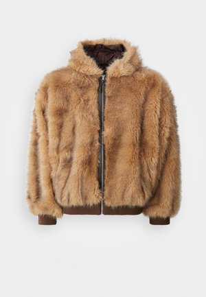 Faux fur-jacka i varm beige med dragkedja, huva och bruna ribbade ärmar och nederkant. Har en mjuk, strukturerad yta.