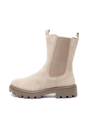 Bottine en suède beige, avec des panneaux latéraux élastiques, une languette de traction et une semelle en caoutchouc épaisse et texturée. Comprend un bout arrondi et un design robuste.