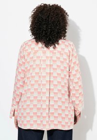 Camicia a maniche lunghe con un design a motivo che presenta forme corallo e bianche su uno sfondo beige. Realizzata in tessuto leggero.