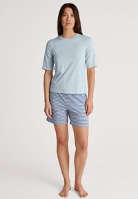 Lichtblauwe kortekraag overhemd gecombineerd met gestreepte shorts in wit en blauw. Gladde stof met een relaxte pasvorm, geen zichtbare hardware of accenten.