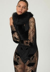 Juodas nėriniuotas suknelė su gėlių siuvinėjimu ir permatomomis detalėmis, kuri turi juodą kailinį apykaklę. Dizainas apima sudėtingus raštus ir tekstūras.