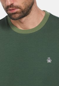 Groen gestreept T-shirt met een geribbelde ronde hals, met een klein wit pinguïnlogo aan de linkerkant. Katoenmengsel stof.