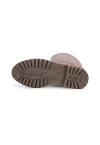 Suela de bota de goma marrón con patrones de textura y crestas, ofreciendo agarre. Bordes reforzados para mayor durabilidad.
