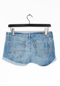 Světle modré džínové šortky s ohrnutými lemy, dvěma zadními kapsami s dekorativním prošitím a koženou štítkem na pásku.