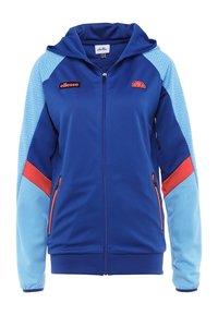 Blå zip-up hoodie med huva, kontrasterande ljusblå ärmar, röda accenter och texturerat mönster på ärmarna. Inkluderar sidofickor.