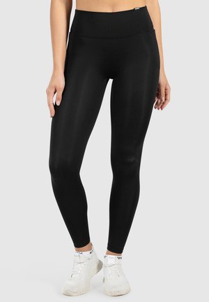 Zwarte legging gemaakt van rekbaar, glad materiaal. Hoogtaille ontwerp met een nauwsluitende pasvorm en zonder zichtbare patronen of hardware.