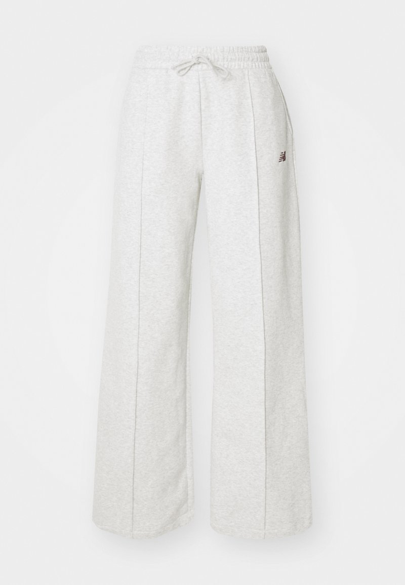 Pantaloni della tuta ampi grigio chiaro realizzati in un tessuto morbido. Presentano una vita con cordoncino e un leggero dettaglio del logo sul lato.