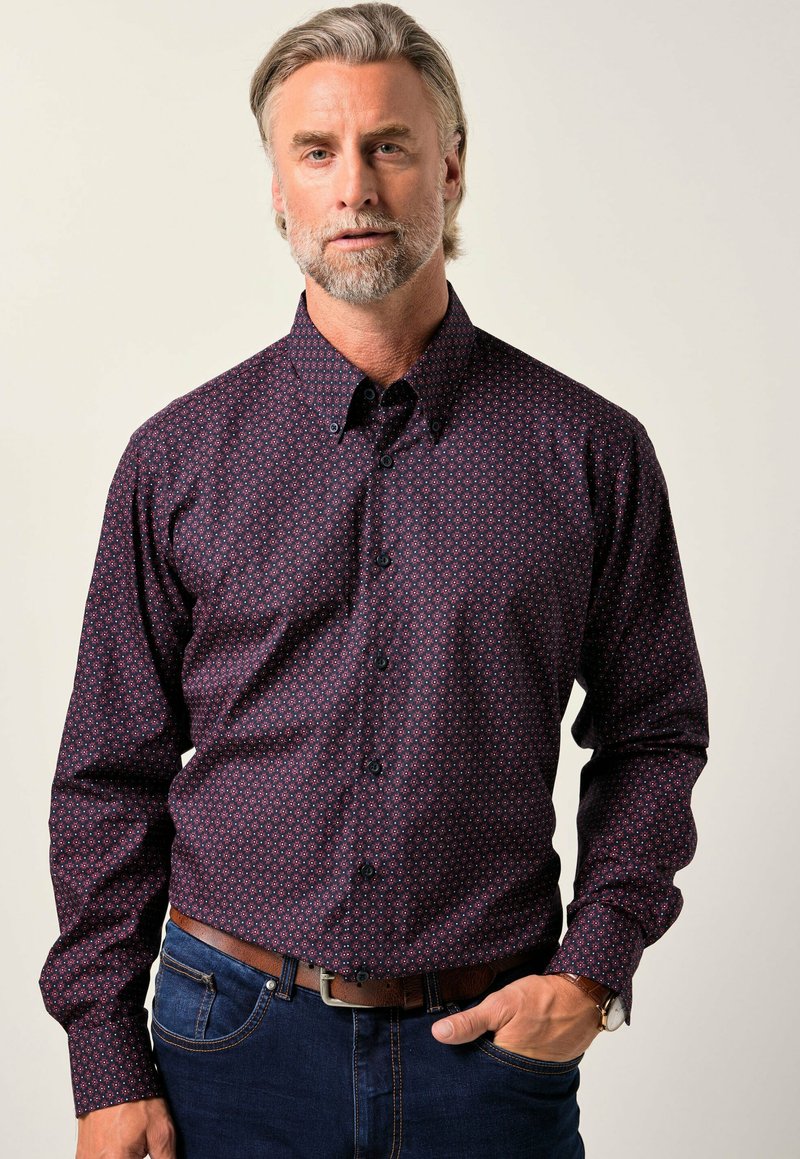 Camicia scura con sfondo bordeaux, caratterizzata da un motivo geometrico dettagliato in blu e rosso chiaro, colletto button-down e maniche lunghe.