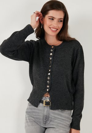 Dark gray cardigan with long sleeves, round neckline, and front button closure featuring metallic buttons and a slightly cropped hem.