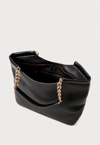 Black leather tote bag with a textured finish, gold chain accents, zippered interior pocket, and soft, wide handles.