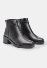 Mustad nahast säärekingad ümarate varvaste, plokktallaga ja külgmise tõmblukuga. Sile pind, minimaalne õmblus ja stiilne disain.