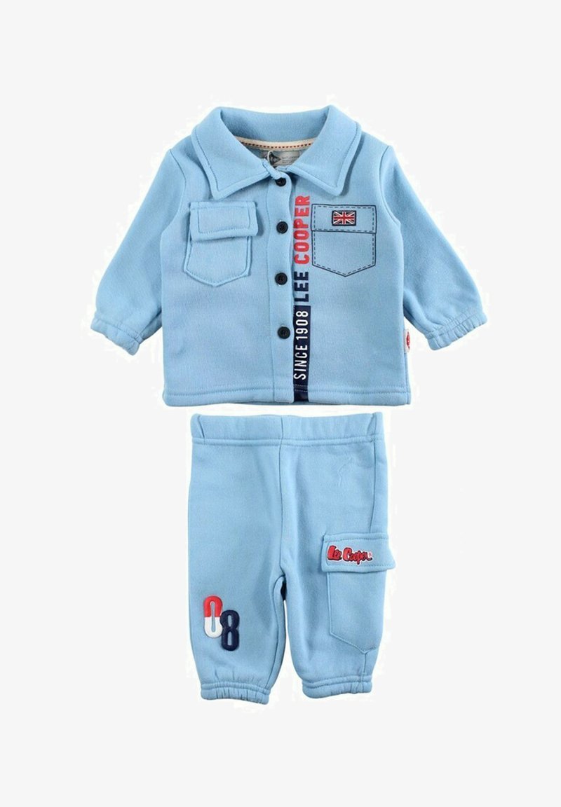 Ensemble deux pièces bleu clair en tissu doux. La chemise comporte un col, des boutons et des patchs décoratifs ; le pantalon dispose de poches latérales et d'accents.