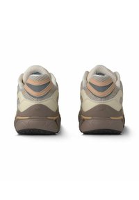 Beige und graue Sneakers mit einem strukturierten Mesh-Obermaterial, gepolstertem Absatz und brauner Gummisohle. Mit einem blauen Akzent am Kragen.