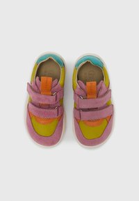 Chaussures pour tout-petit colorées en daim rose, vert et bleu, avec deux brides velcro et une semelle extérieure en caoutchouc, présentant un bout rond et diverses touches de couleurs.