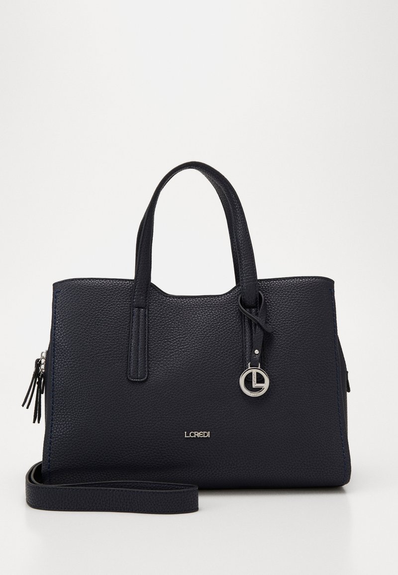 Sac à main en cuir bleu marine avec une finition texturée, deux poignées, une bandoulière détachable et un charm en argent. Design spacieux et structuré.
