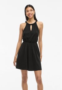 Fekete nyakpántos ruha, gyűrt nyakkivágással és kulcslyuk részlettel. Gumis derék, bőszoknya, puha, könnyű anyagból készült.