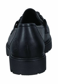 Zapato de cuero negro con textura suave, parte trasera redondeada y suela plana de goma. Presenta un logo emblazonado en el talón.