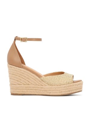 Kožené klinové sandále v hnedej farbe so zapleteným prírodným vláknom. Majú otvorenú špičku, remienok okolo členka so sponou a textúrovanú platformu.