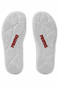 Weiße Gummisandalensohlen mit einem strukturierten Grip-Muster und rotem "reima"-Logo. Das Design umfasst erhabene Linien und Konturen für besseren Halt.