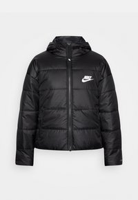 Svart boblejakke med glidelås og hette. Har kviltet design, sidelommer og en hvit Nike-logo på venstre bryst.