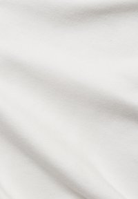 White cotton fabric with a smooth, soft texture, displaying subtle shadows and creases across the surface.