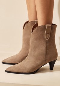 Burgunderfarbene Wildleder-Stiefeletten mit spitzem Kopf und kleinem schwarzen Absatz. Verfügt über ein ausgeschnittenes Design und eine Schlaufe hinten für einfacheres Anziehen.
