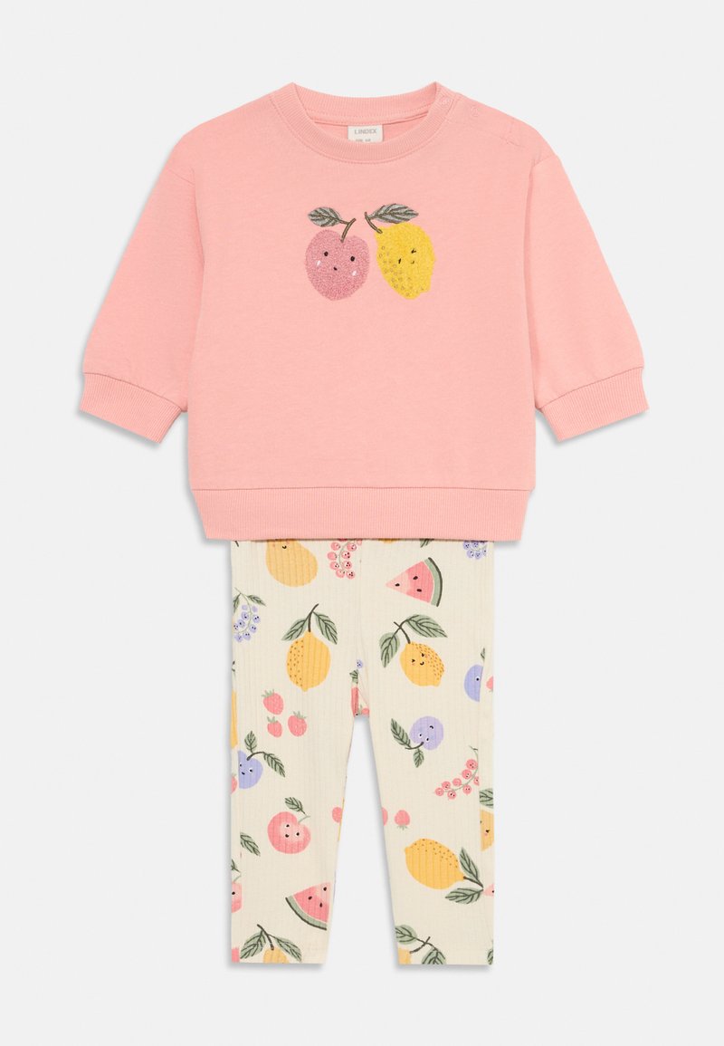 Rosa hettegenser med to fruktdesign, og kremfargede tights med et fargerikt fruktmønster. Myk stoff og ribbede mansjetter.