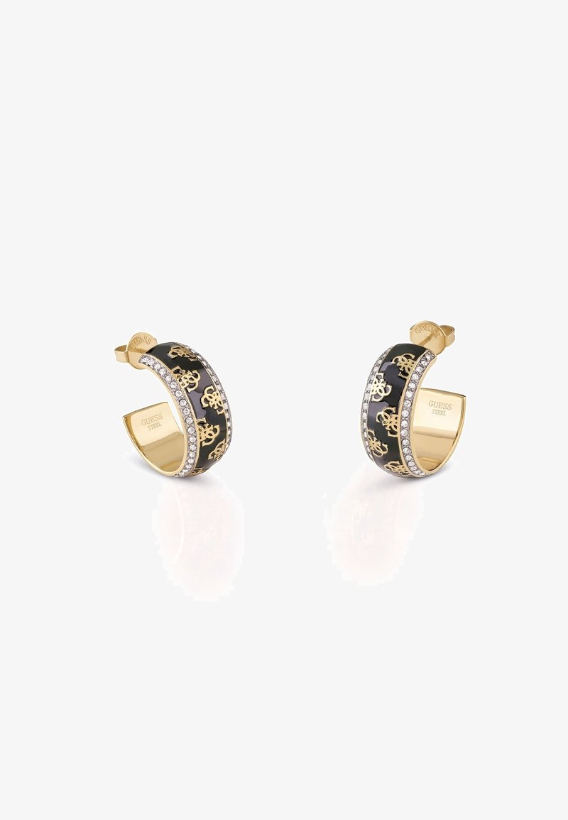 Boucles d'oreilles créoles ton or avec émail noir, motifs de logo dorés et rangées de petits cristaux transparents le long des bords, gravées "GUESS STEEL" à l'intérieur.