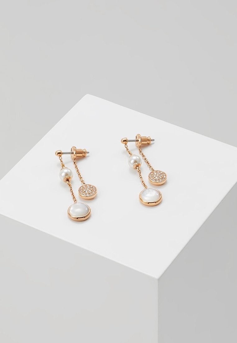Boucles d'oreilles gouttes en or rose avec deux chaînes, chacune ornée d'une petite perle et de charms ronds avec des pierres blanches et scintillantes.