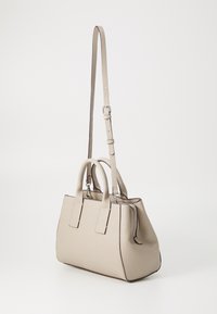 Beige leather handbag with a textured finish, dual top handles, and a long adjustable strap. Features a zip closure and contrasting trim.