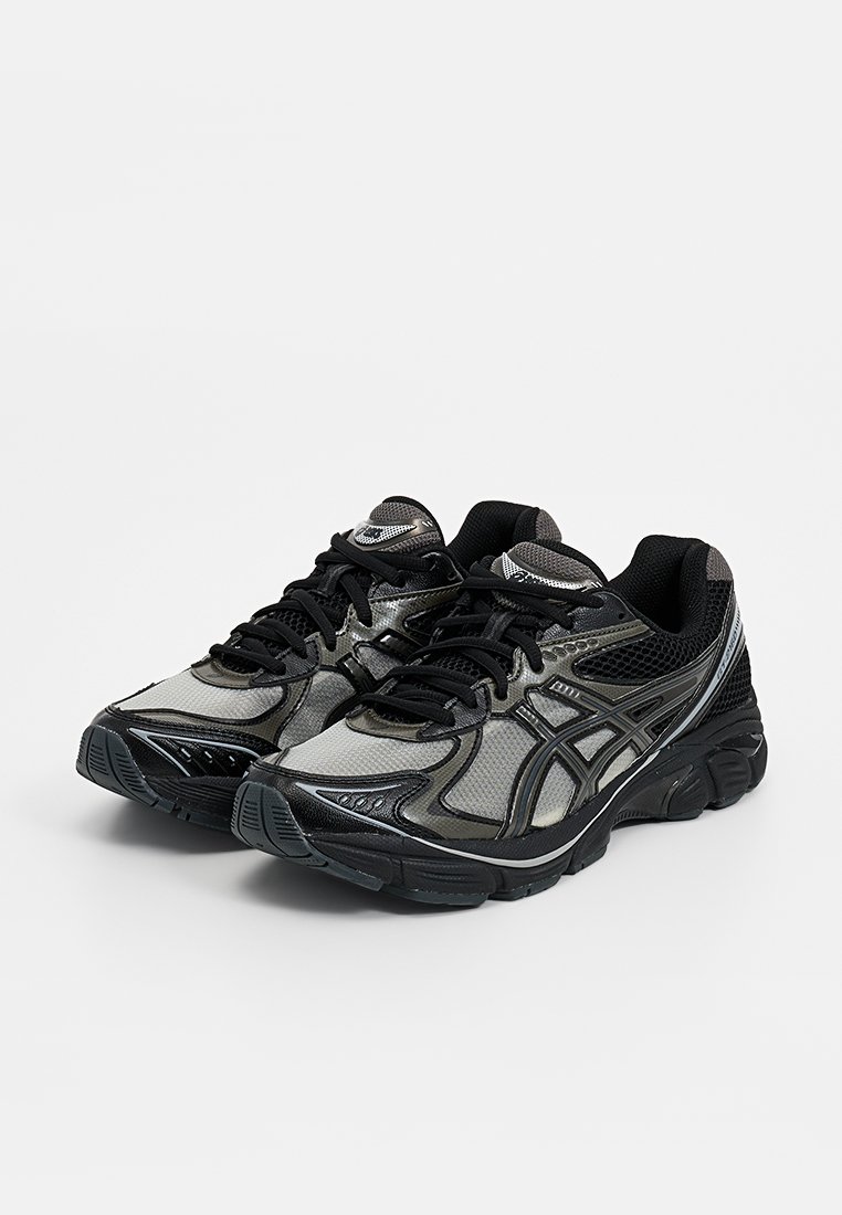 Des chaussures de course noires et argentées avec des panneaux en mesh, un col rembourré, une semelle en caoutchouc texturée et un système de laçage.