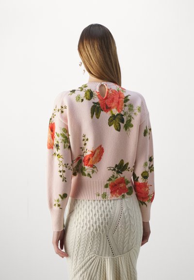Pink knitted sweater with floral patterns featuring red roses and green leaves. Ribbed cuffs and hem, with a keyhole detail at the back.