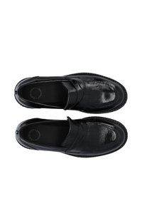 Melni ādas loafers ar spīdīgu apdari, kas piedāvā gludu augšu ar dekoratīviem franjām un plakanu, teksturētu zoli.
