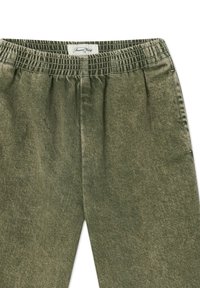 Olivgröna byxor med resårmidja, i ett strukturerat tyg och med rakt ben. Etikett sydd på insidan av midjan.