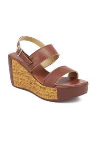 Sandali wedge marroni con due ampie cinghie in pelle e una base testurizzata simile al sughero. La piattaforma è voluminosa con una suola in gomma liscia.