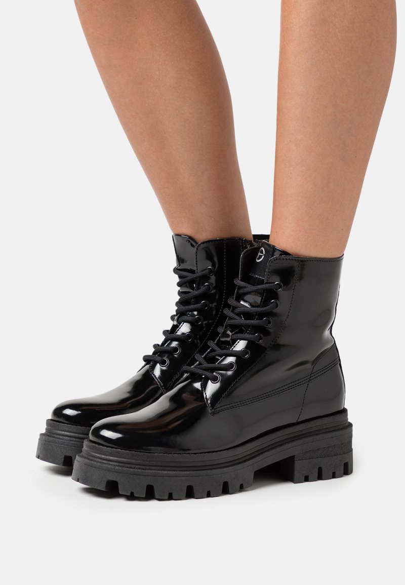 Must musta nahkasaapad ümara ninaga, paeltega esiosal ja tekstureeritud kummitaldadega. Siledat viimistlust ja vastupidavad disainielemendid.