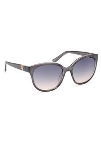 Gafas de sol grises translúcidas con lentes de degradado de oscuro a claro. Presentan un acento en oro rosa en la bisagra y un diseño de montura redondeada.