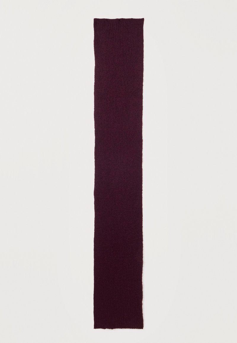 Longue écharpe tricotée violet foncé avec une texture douce posée à plat sur un fond clair.