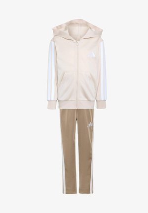 Chándal Adidas beige y marrón claro con chaqueta con capucha y cremallera y pantalones a juego, con franjas blancas y logotipos de Adidas en las mangas y la pierna.