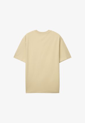 T-shirt à manches courtes couleur beige avec un col rond. Tissu en coton lisse, coupe décontractée, design uni. Aucun motif ou accent visible.