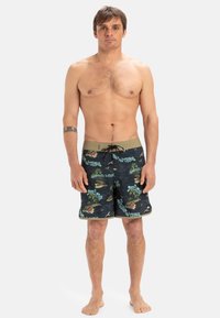 Schwarze Boardshorts mit tropischem Grafikdruck und grünen Akzenten sowie einem Kordelzugbund. Hergestellt aus leichtem, schnelltrocknendem Material.