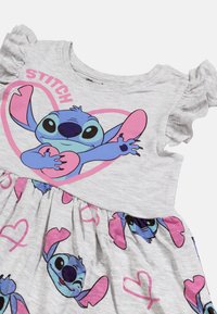 Szara bawełniana sukienka z falbaniastymi krótkimi rękawami, dużą grafiką Stitche'a z różowymi serduszkami oraz marszczoną spódnicą z powtarzającymi się wzorami Stitche'a.