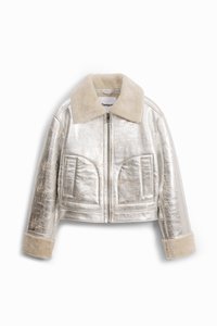 Beskarvet jakke lavet af skinnende metallic sølvstof, med en blød beige krave, to frontlommer og lynlås.