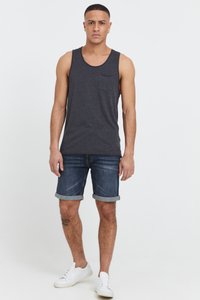 Mörkgrå linne med ficka, tillsammans med uppvikta denimshorts och vita sneakers. Enkel design och bomullsstruktur.
