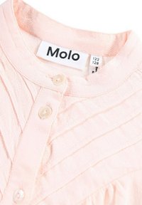 Rosa bomullsskjorta med ett strukturerat mönster, utrustad med en rund krage, två knappar framtill och en etikett med texten "Molo" vid halslinningen.