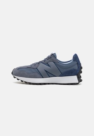 Baskets bleu foncé et gris avec lacets, panneau latéral texturé et semelle blanche avec bande de roulement noire, vues du côté extérieur sur fond blanc.