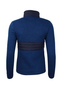 Giacca blu navy con un corpo a maglia testurizzata e una vita liscia e imbottita. Presenta un colletto alto e maniche lunghe.