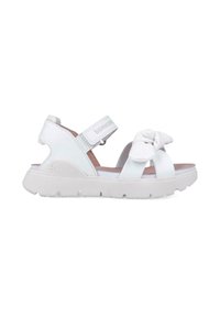 Sandalias blancas con cinta de Velcro ajustable, detalle decorativo de nudo en la parte delantera, textura suave, suela de goma y diseño que proporciona soporte.